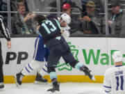 Toronto Maple Leafs defenseman Jake McCabe (22) and Seattle Kraken left wing Brandon Tanev (13) fight during the first period of an NHL hockey game Sunday, Jan. 21, 2024, in Seattle.