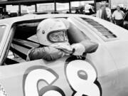 FILE - Between practice runs for the World 600, Janet Guthrie leans out of the window of the stock car racer in Charlotte, N.C., May 29, 1976. Guthrie will be inducted into the NASCAR Hall of Fame on Friday night, Jan.