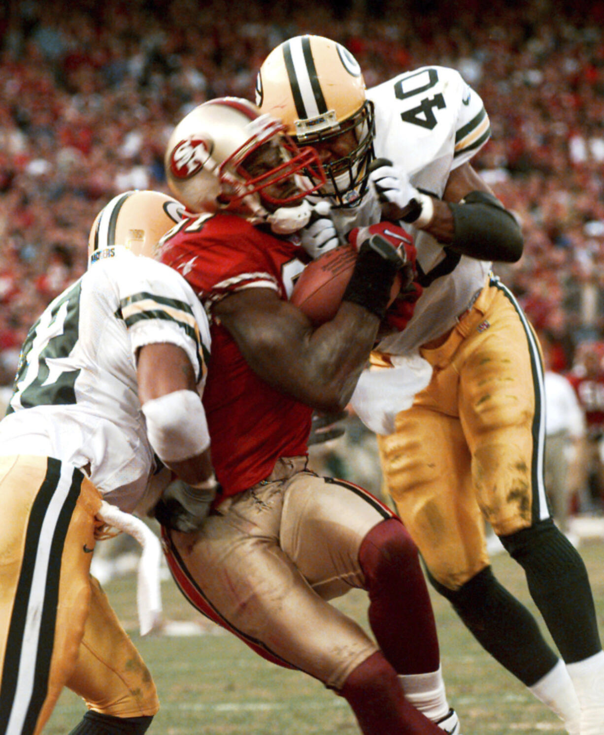 FILE - San Francisco 49ers wide receiver Terrell Owens pulls in a 25-yard touchdown pass from quarterback Steve Young as Green Bay Packers&rsquo; safeties Pat Terrell (40) and Darren Sharper defend late in the fourth quarter of an NFC wild-card NFL football playoff game in San Francisco on Jan. 3, 1999. Owens&rsquo; catch with 3 seconds left in the game led the 49ers to a 30-27 win.