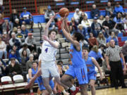 Cole Chester of Ridgefield (4) flips a pass over Dalton Stevens of Mark Morris in a 2A Greater St. Helens League boys basketball game at Mark Morris High School on Saturday, January 20, 2024.