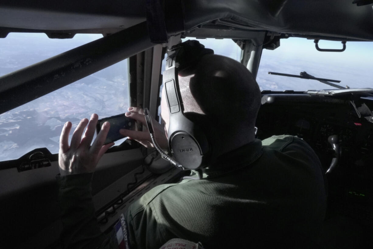 A crew member snaps a souvenir photo from the cockpit of a French military AWACS surveillance plane as it flies a 10-hour mission Tuesday, Jan. 9, 2024, to eastern Romania for the NATO military alliance. During the 2024 Olympics in July and August, France&rsquo;s AWACS will be used to provide an extra layer of radar surveillance over the Paris Games.