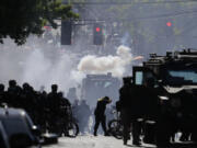 FILE - Smoke rises as police clash with protester during a Black Lives Matter protest near the Seattle Police East Precinct headquarters, July 25, 2020, in Seattle. Seattle has agreed to pay $10 million to 50 demonstrators who sued over the police department&rsquo;s heavy-handed response to racial justice protests in 2020, attorneys for both sides said Wednesday, Jan. 24, 2024. (AP Photo/Ted S.