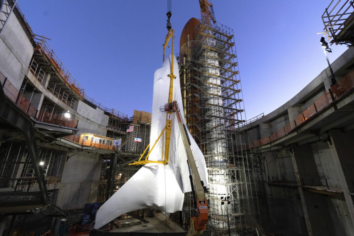 Workers finish fastening the Space Shuttle Endeavour at the site of the future Samuel Oschin Air and Space Center on Tuesday, Jan. 30, 2024, in Los Angeles. NASA&rsquo;s retired Space Shuttle Endeavour was carefully hoisted late Monday to be mated to a huge external fuel tank and its two solid rocket boosters at a Los Angeles museum where it will be uniquely displayed as if it is about to blast off.