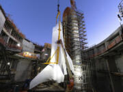 Workers finish fastening the Space Shuttle Endeavour at the site of the future Samuel Oschin Air and Space Center on Tuesday, Jan. 30, 2024, in Los Angeles. NASA&rsquo;s retired Space Shuttle Endeavour was carefully hoisted late Monday to be mated to a huge external fuel tank and its two solid rocket boosters at a Los Angeles museum where it will be uniquely displayed as if it is about to blast off.