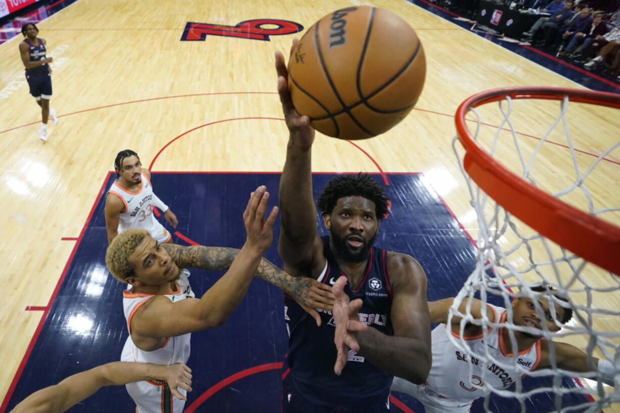 Philadelphia 76ers&rsquo; Joel Embiid, center, goes up for a shot between San Antonio Spurs&rsquo; Jeremy Sochan, left, and Keldon Johnson during the second half of an NBA basketball game, Monday, Jan. 22, 2024, in Philadelphia.