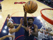 Philadelphia 76ers&rsquo; Joel Embiid, center, goes up for a shot between San Antonio Spurs&rsquo; Jeremy Sochan, left, and Keldon Johnson during the second half of an NBA basketball game, Monday, Jan. 22, 2024, in Philadelphia.