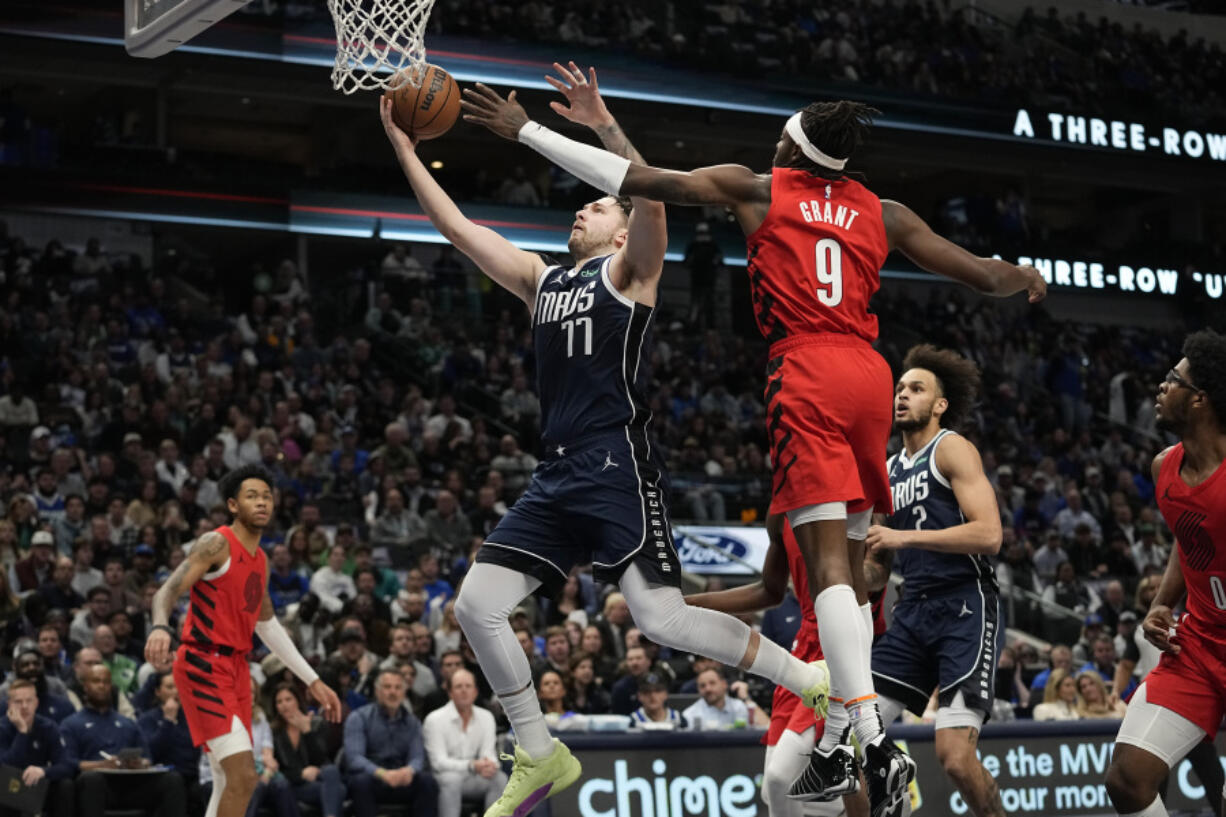 Dallas Mavericks guard Luka Doncic (77) drives to the basket against Portland Trail Blazers forward Jerami Grant (9) during the first half of an NBA basketball game in Dallas, Wednesday, Jan. 3, 2024.