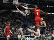 Dallas Mavericks guard Luka Doncic (77) drives to the basket against Portland Trail Blazers forward Jerami Grant (9) during the first half of an NBA basketball game in Dallas, Wednesday, Jan. 3, 2024.