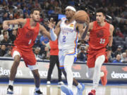 Oklahoma City Thunder Shai Gilgeous-Alexander (2) drives past Portland Trail Blazers forwards Kris Murray (8) and Toumani Camara (33) in the second half of an NBA basketball game, Thursday, Jan. 11, 2024, in Oklahoma City.