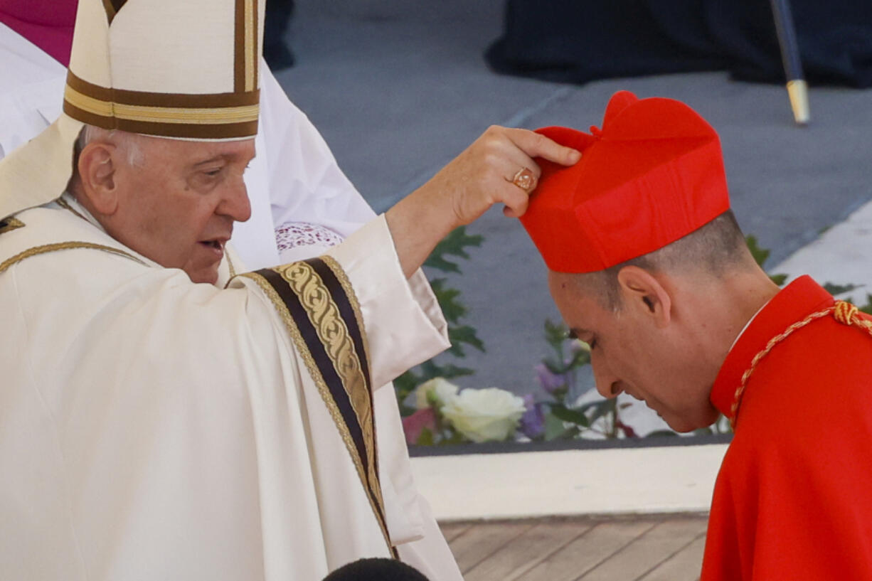 Newly elected Cardinal V&iacute;ctor Manuel Fern&aacute;ndez, Prefect of the Dicastery for the Doctrine of the Faith, right, receives his biretta from Pope Francis on Sept. 30, as he is elevated in St. Peter&rsquo;s Square at The Vatican.