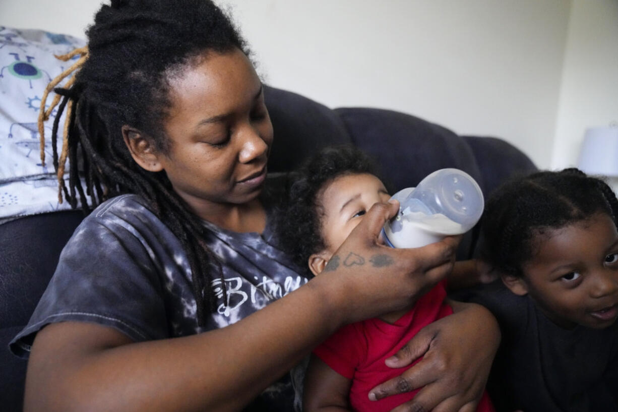 Ashley Yancey feeds her 11 month-old daughter Olivia as two-year old Oliver Tolvert looks on at right Thursday, Dec. 14, 2023, in Douglasville, Ga. Yancey, who doesn&rsquo;t own a car, recently tried to find formula for her daughter at a Target about 30 miles from her home in and was stunned the location didn&rsquo;t accept WIC. Often, her nearest WIC vendor is out of the product.