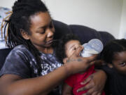 Ashley Yancey feeds her 11 month-old daughter Olivia as two-year old Oliver Tolvert looks on at right Thursday, Dec. 14, 2023, in Douglasville, Ga. Yancey, who doesn&rsquo;t own a car, recently tried to find formula for her daughter at a Target about 30 miles from her home in and was stunned the location didn&rsquo;t accept WIC. Often, her nearest WIC vendor is out of the product.