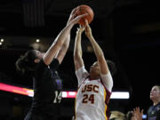 Washington forward Dalayah Daniels (14) blocks a shot by Southern California forward Kaitlyn Davis (24) during the second half of an NCAA college basketball game in Los Angeles, Sunday, Jan. 28, 2024.