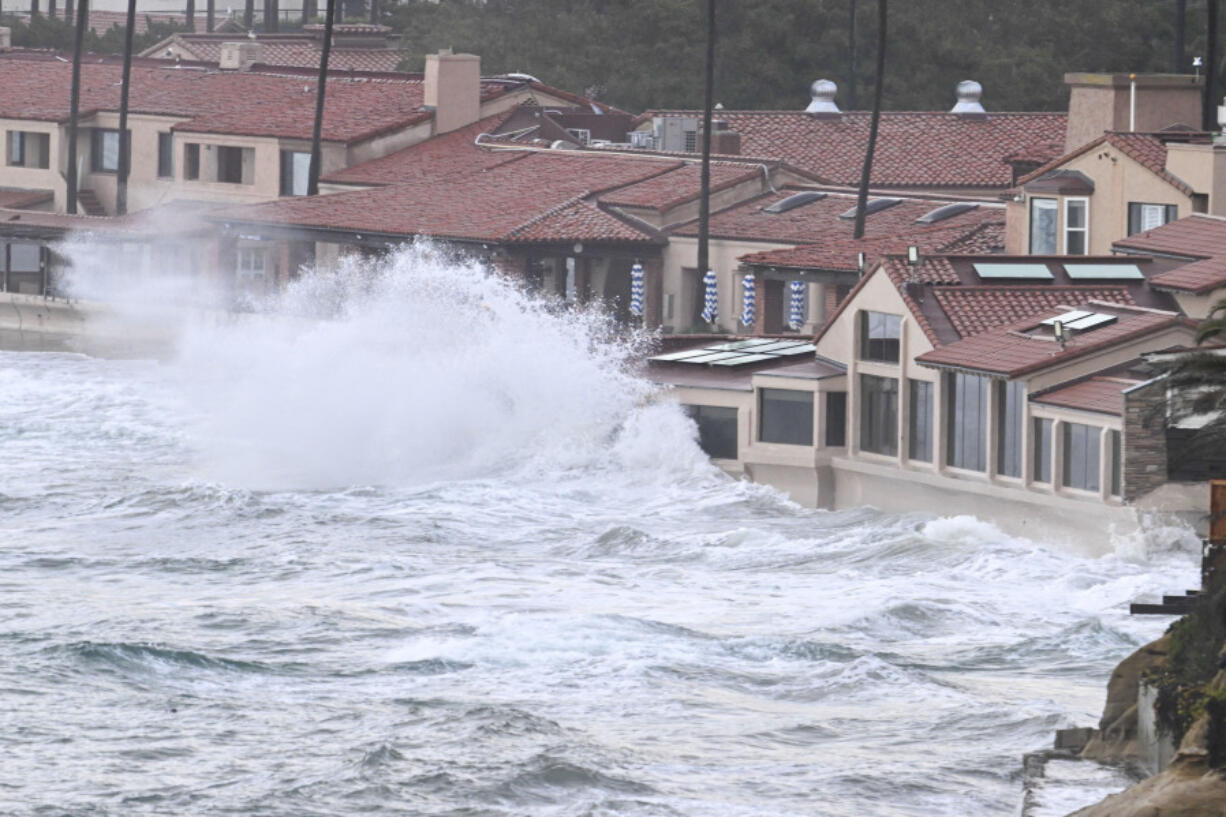 Waves crash into the windows of the Marine Room restaurant Tuesday, Jan. 23, 2024, in La Jolla, Calif. The restaurant is reinforced for the surf and no damage was done.  California Gov.