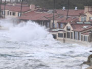 Waves crash into the windows of the Marine Room restaurant Tuesday, Jan. 23, 2024, in La Jolla, Calif. The restaurant is reinforced for the surf and no damage was done.  California Gov.