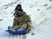 A bundled-up Beau Schilly, 6, sleds down a hill Monday in Jonesboro, Ark. Experts recommend dressing in layers if you must go out in the bitter cold.