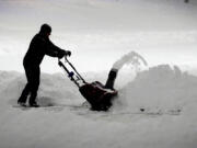 A local resident clears overnight snow from a driveway, Tuesday, Jan. 9, 2024, in Urbandale, Iowa.