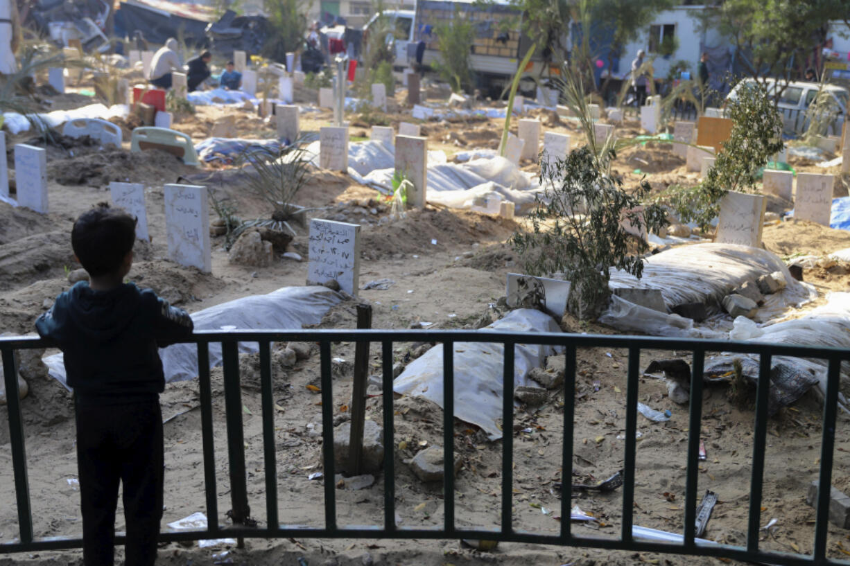 FILE - A Palestinian child looks at the graves of people killed in the Israeli bombardment of the Gaza Strip and buried inside the Shifa Hospital grounds in Gaza City, Sunday, Dec. 31, 2023. South Africa has launched a case at the United Nations&rsquo; top court alleging that Israel&rsquo;s military campaign in Gaza amounts to genocide. The filing and Israel&rsquo;s decision to defend itself at the International Court of Justice sets up a high-stakes showdown in the before a bench of the court&rsquo;s black-robed judges in the wood-panelled Great Hall of Justice.