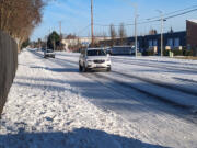 Drivers make their way down snowy streets on 121St Avenue in east Vancouver on Monday.