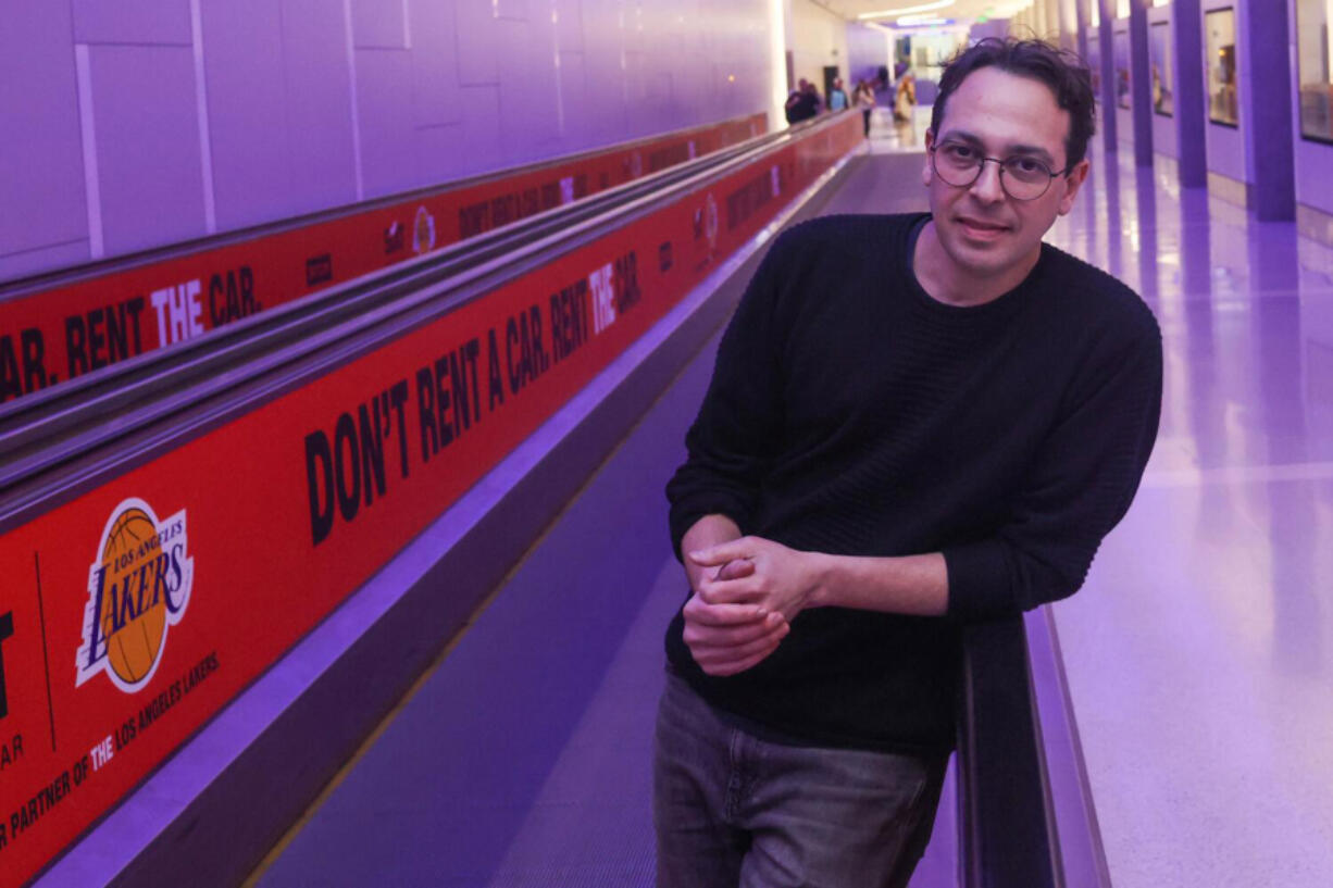 Dublab Executive Director Alejandro Cohen poses for a portrait on the moving walkway at LAX on Jan. 18, 2023, in Los Angeles. Curated by the LA radio station Dublab, the orchestrina takes short original compositions from 30 LA composers and musicians and blends them into a seamless, ever-evolving ambient soundtrack for traveling between gates in a new pedestrian tunnel.