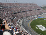 FILE - A sold out crowd watches as Alex Bowman, front left, and Kyle Larson, front right, lead the field to start the NASCAR Daytona 500 auto race at Daytona International Speedway, Sunday, Feb. 19, 2023, in Daytona Beach, Fla. A new NASCAR season begins with rivals attempting to dethrone Team Penske after two years atop the Cup Series, all while a compelling off-track battle rages on over revenue sharing that threatens to overshadow the competition.