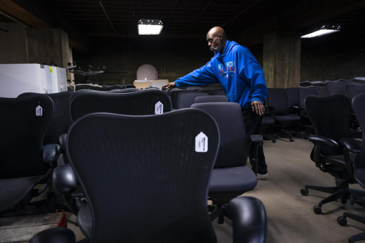 Aaron Mason, an employee at Furniture Office &amp; Home, sorts office chairs into rows on Feb. 1, 2024, in Minneapolis. The store receives donations or buys in bulk from downsizing offices and resells the furniture at second-hand prices -- a business model that has become quite profitable with the post-pandemic rise of remote work.