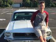 Washougal High School graduate Alec Langen poses for a photograph with his car in his school parking space in 2018.