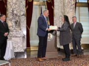 Gov. Jay Inslee presents Washington&rsquo;s Medal of Valor to Constance Chin Magorty, the sister of Donnie Chin, who founded the the International District Emergency Center in Seattle and died in a 2015 shooting. Secretary of State Steve Hobbs is to the left, and to the right is State Supreme Court Chief Justice Steven Gonzalez.