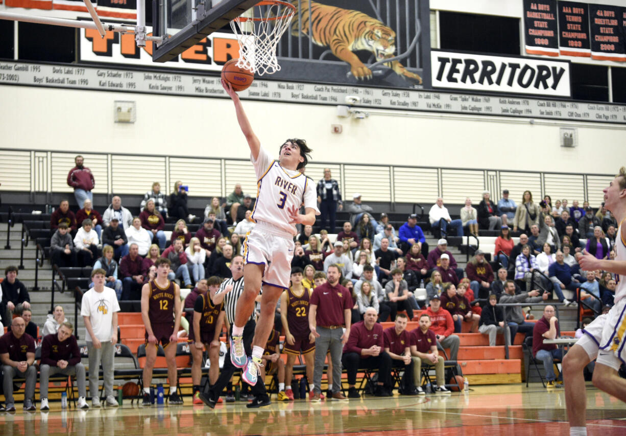 Columbia River’s Ari Richardson (3) scores an uncontested layup as the White River bench looks on during a Class 2A State Opening Round boys basketball game on Saturday, Feb. 24, 2024, at Battle Ground High School.