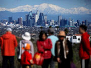 Newly snow-capped San Gabriel Mountains enhance the view of downtown Los Angeles from the Kenneth Hahn State Recreation Area in Baldwin Hills on Saturday.