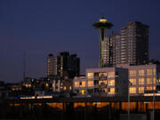 The Space Needle is seen as the setting sun reflects off of nearby apartments, Sunday, Oct. 29, 2023, in Seattle.