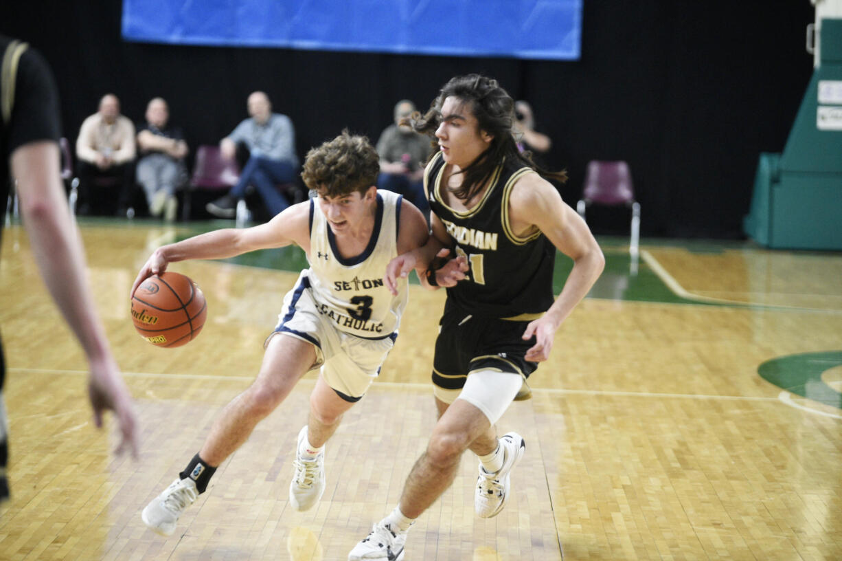 Seton Catholic's Brady Angelo, left, drives against Merdian's Taran Burks in a Class 1A boys round of 12 state basketball game on Wednesday, Feb. 28, 2024 in Yakima.