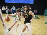 Seton Catholic's Brady Angelo, left, drives against Merdian's Taran Burks in a Class 1A boys round of 12 state basketball game on Wednesday, Feb. 28, 2024 in Yakima.