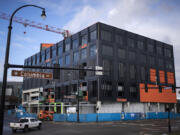 A motorist passes by a construction project that is a seven-story, 194-unit apartment building with 4,549 square feet of commercial space and 177 associated parking spaces at the Waterfront Vancouver on Tuesday morning, Feb. 6, 2024.