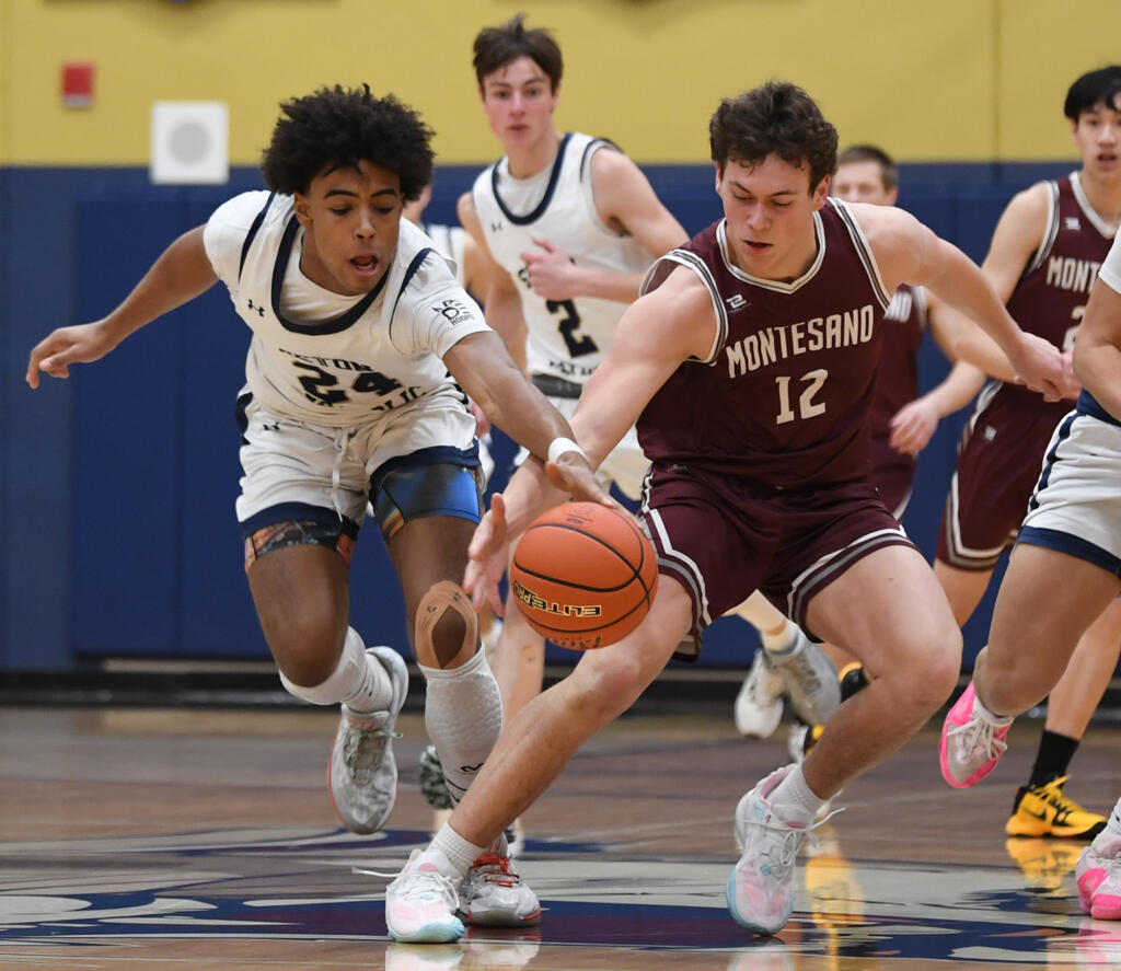 Seton Catholic freshman Kaiden Wilson, left, and Montesano senior Gabe Bodwell fight for a loose ball Friday, Feb. 9, 2024, during the Cougars’ 58-46 win against Montesano at Seton Catholic High School.