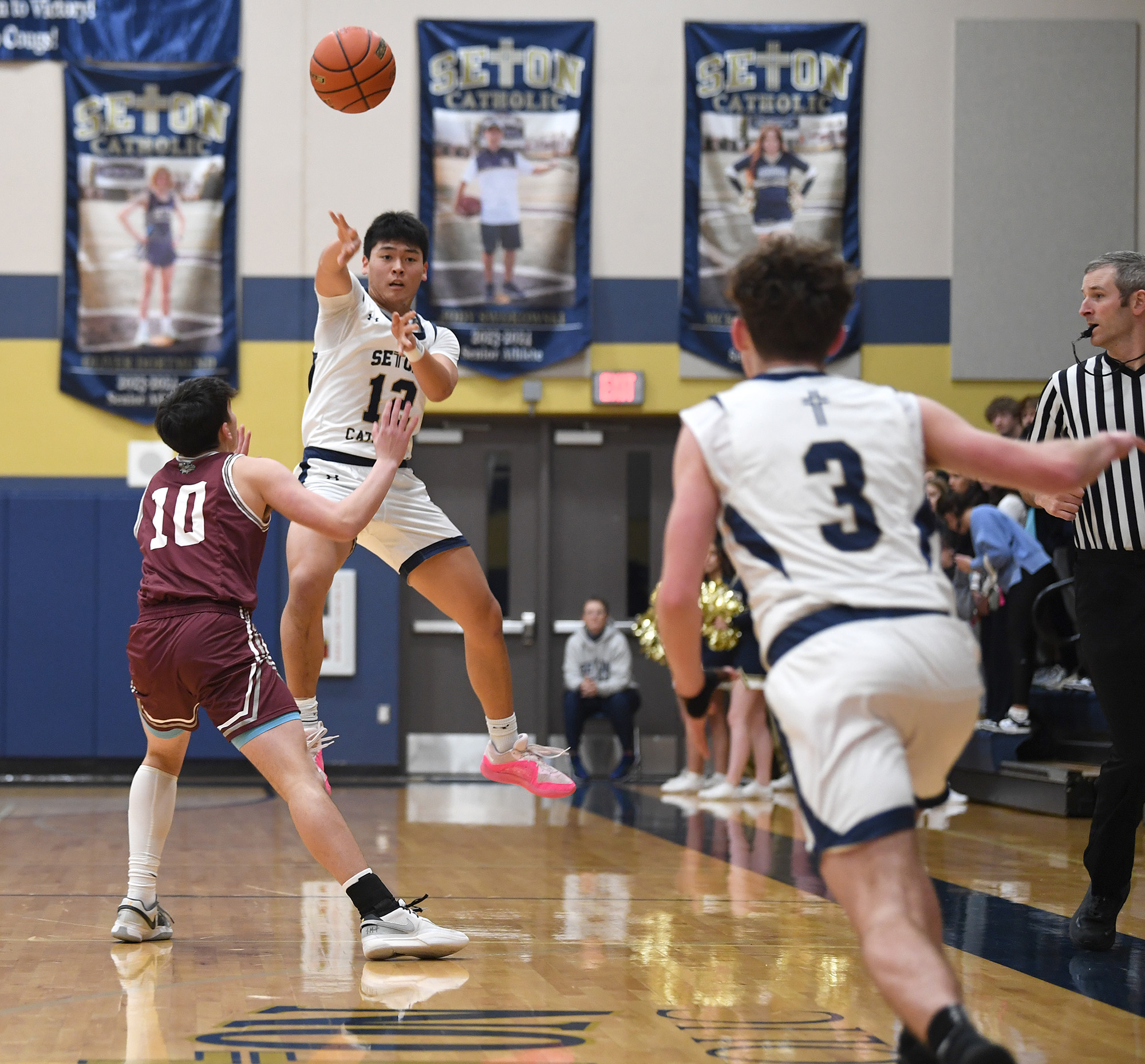 Seton Catholic junior Lance Lee (12) passes the ball to junior Brady AngeloFriday, Feb. 9, 2024, during the Cougars’ 58-46 win against Montesano at Seton Catholic High School.