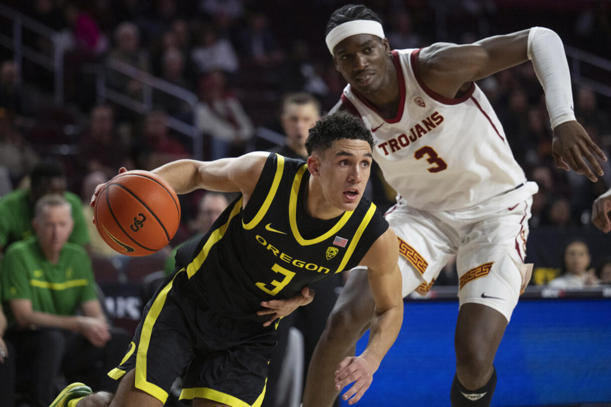 Oregon guard Jackson Shelstad, left, drives to the basket as Southern California forward Vincent Iwuchukwu defends during the second half of an NCAA college basketball game Thursday, Feb. 1, 2024 in Los Angeles.