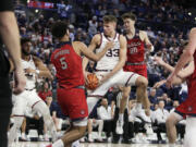 Gonzaga forward Ben Gregg (33) grabs a rebound between Saint Mary's forward Joshua Jefferson (5) and guard Aidan Mahaney (20) during the second half of an NCAA college basketball game, Saturday, Feb. 3, 2024, in Spokane, Wash.