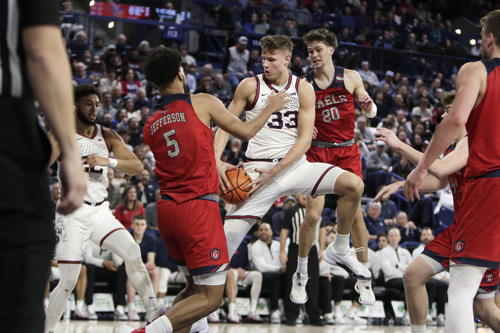 Gonzaga forward Ben Gregg (33) grabs a rebound between Saint Mary's forward Joshua Jefferson (5) and guard Aidan Mahaney (20) during the second half of an NCAA college basketball game, Saturday, Feb. 3, 2024, in Spokane, Wash.