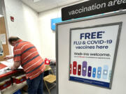 FILE - A sign for flu and covid vaccinations is displayed at a pharmacy store in Palatine, Ill., Wednesday, Sept. 13, 2023. The flu is hanging on in the U.S., intensifying in some areas of the country after weeks of apparent decline., according to data released by the U.S. Centers for Disease Control and Prevention on Friday, Feb. 9, 2024. (AP Photo/Nam Y.