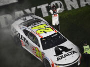 William Byron celebrates while standing on his car after winning the NASCAR Daytona 500 auto race at Daytona International Speedway, Monday, Feb. 19, 2024, in Daytona Beach, Fla. (AP Photo/Phelan M.