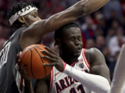 Washington State center Rueben Chinyelu (20) defends against Arizona center Oumar Ballo (11) under the basket during the first half of an NCAA college basketball game Thursday, Feb. 22, 2024, in Tucson, Ariz.