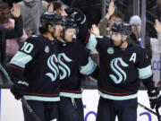 Seattle Kraken right wing Jordan Eberle, right, celebrates his goal against the Vancouver Canucks with left wing Jared McCann, center, and center Matty Beniers, left, during the third period of an NHL hockey game Thursday, Feb. 22, 2024, in Seattle.