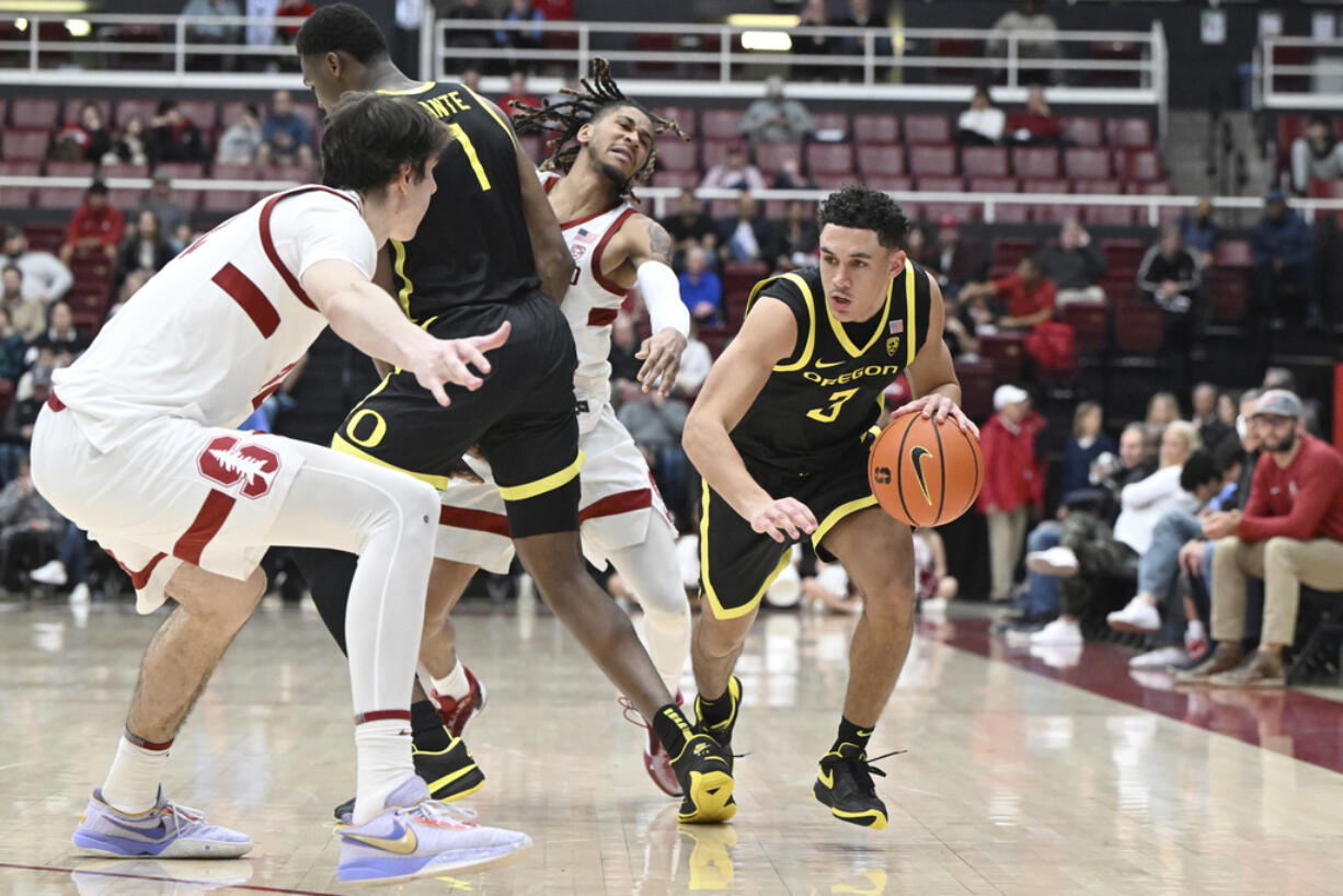 Oregon guard Jackson Shelstad (3) drives as Stanford forward Maxime Raynaud (42) watches during the second half of an NCAA college basketball game Thursday, Feb. 22, 2024, in Stanford, Calif.