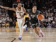 Washington State guard Myles Rice (2) struggles to get around Arizona State guard Frankie Collins (1) during the first half of an NCAA college basketball game Saturday, Feb. 24, 2024, in Tempe, Ariz.