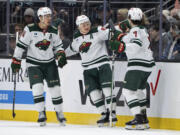 Minnesota Wild forward Kirill Kaprizov, center, forward Joel Eriksson Ek, left, and defenseman Brock Faber celebrate a goal against the Seattle Kraken during the second period of an NHL hockey game Saturday, Feb. 24, 2024, in Seattle.