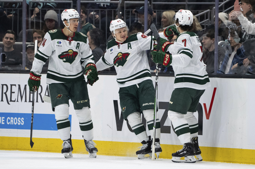 Minnesota Wild forward Kirill Kaprizov, center, forward Joel Eriksson Ek, left, and defenseman Brock Faber celebrate a goal against the Seattle Kraken during the second period of an NHL hockey game Saturday, Feb. 24, 2024, in Seattle.