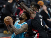 Charlotte Hornets center Nick Richards, left, shoots in front of Portland Trail Blazers center Deandre Ayton during the second half of an NBA basketball game in Portland, Ore., Sunday, Feb. 25, 2024.