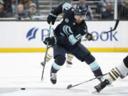 Seattle Kraken forward Matty Beniers skates with the puck against the Boston Bruins during the second period of an NHL hockey game, Monday, Feb. 26, 2024, in Seattle.