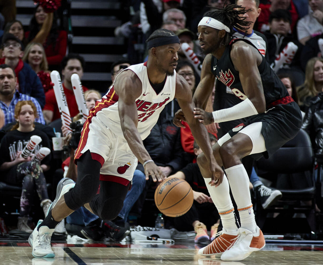 Miami Heat forward Jimmy Butler, left, dribbles around Portland Trail Blazers forward Jerami Grant during the second half of an NBA basketball game in Portland, Ore., Tuesday, Feb. 27, 2024.